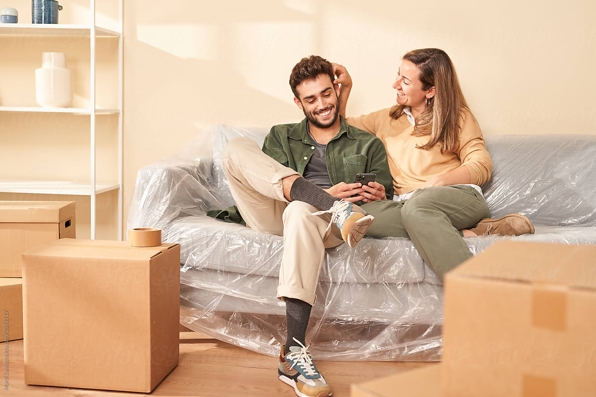 Young couple chilling on couch during relocation