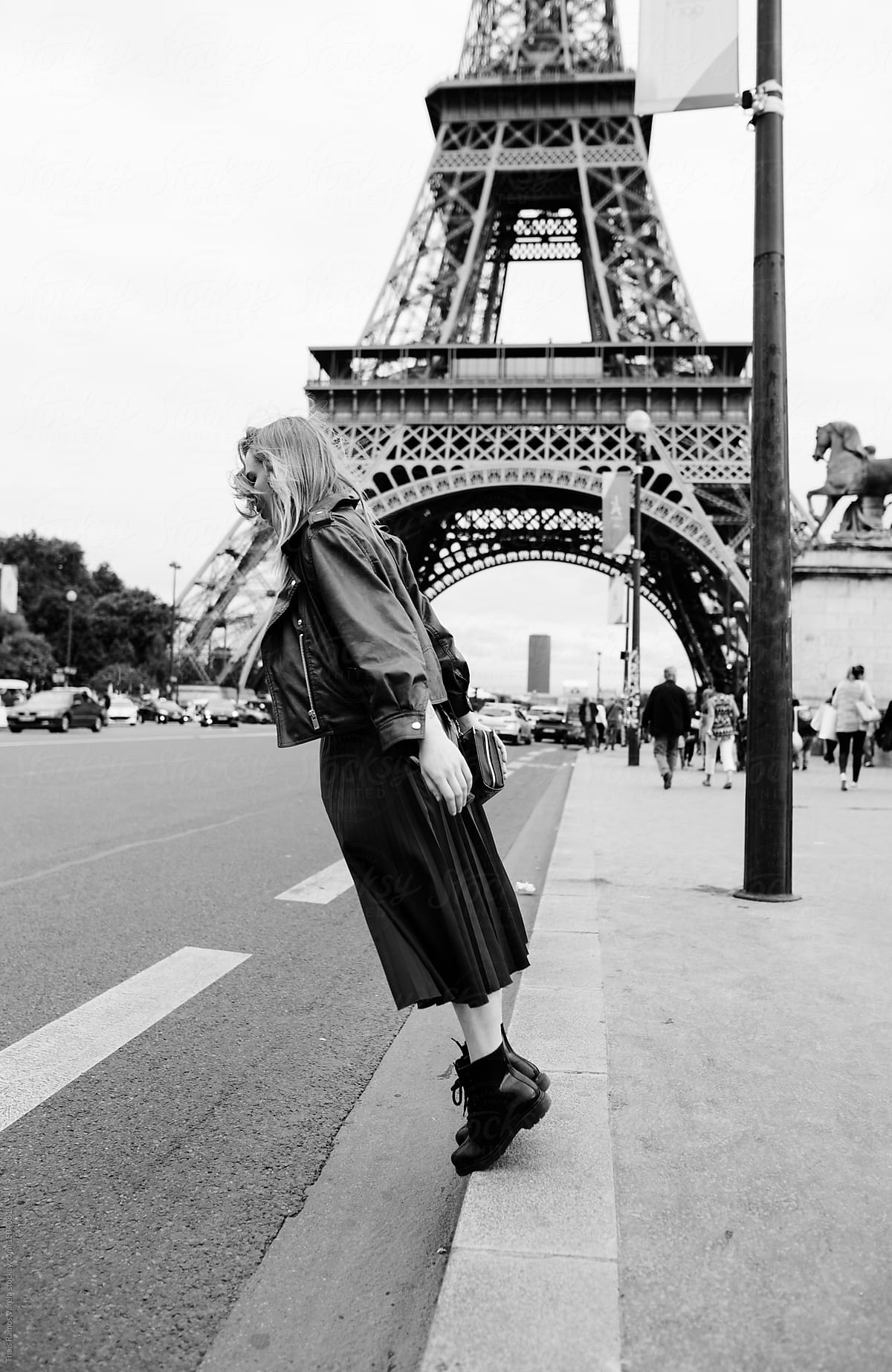 stylish woman having fun in front of the eiffel tower in black and white