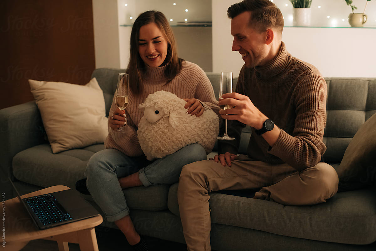 Young couple with glasses of wine chatting online