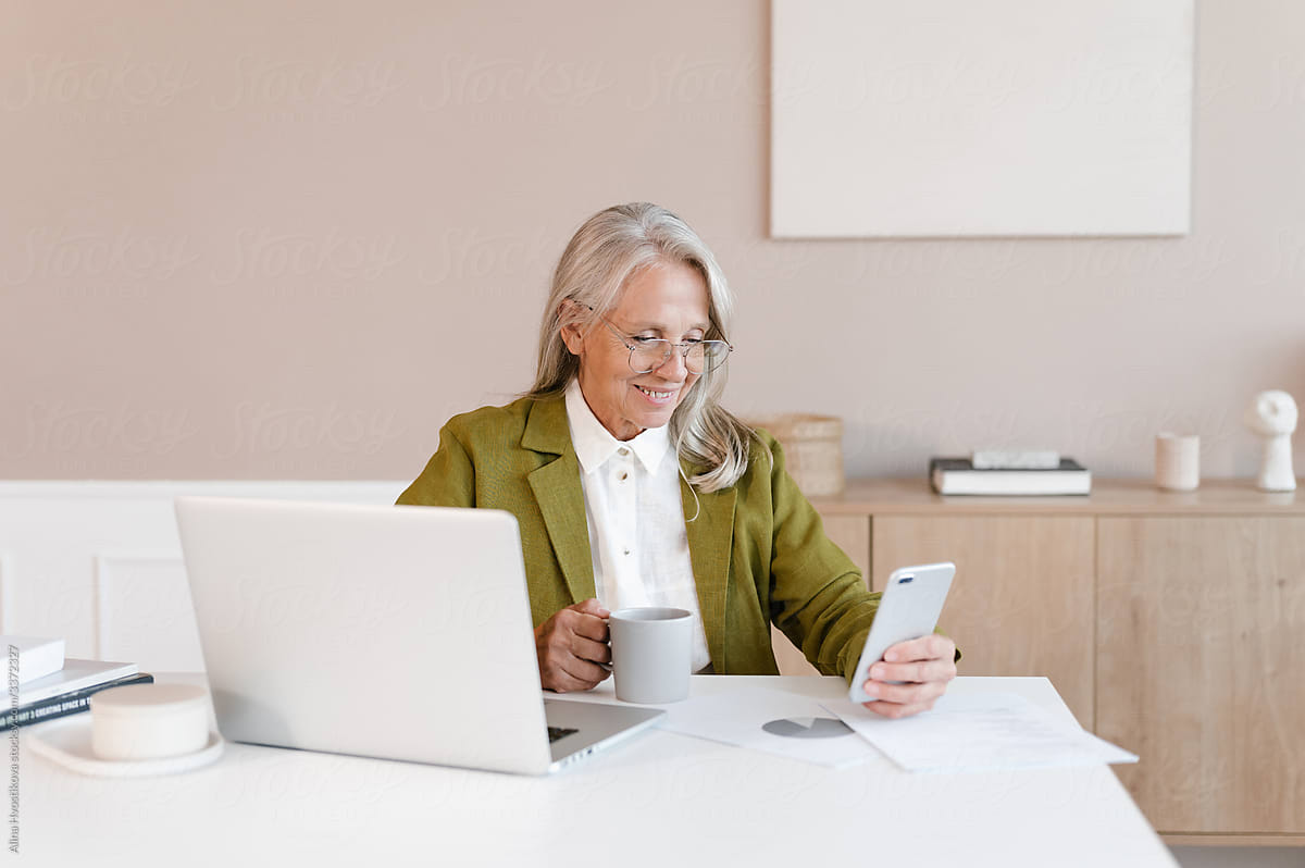 Aged employee browsing smartphone during break