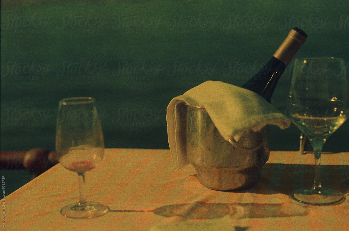 An empty glass and a wine bottle on a table