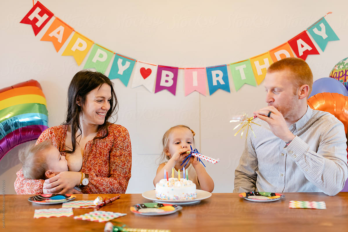 A Happy Family Blows on Party Horns at a Birthday Party