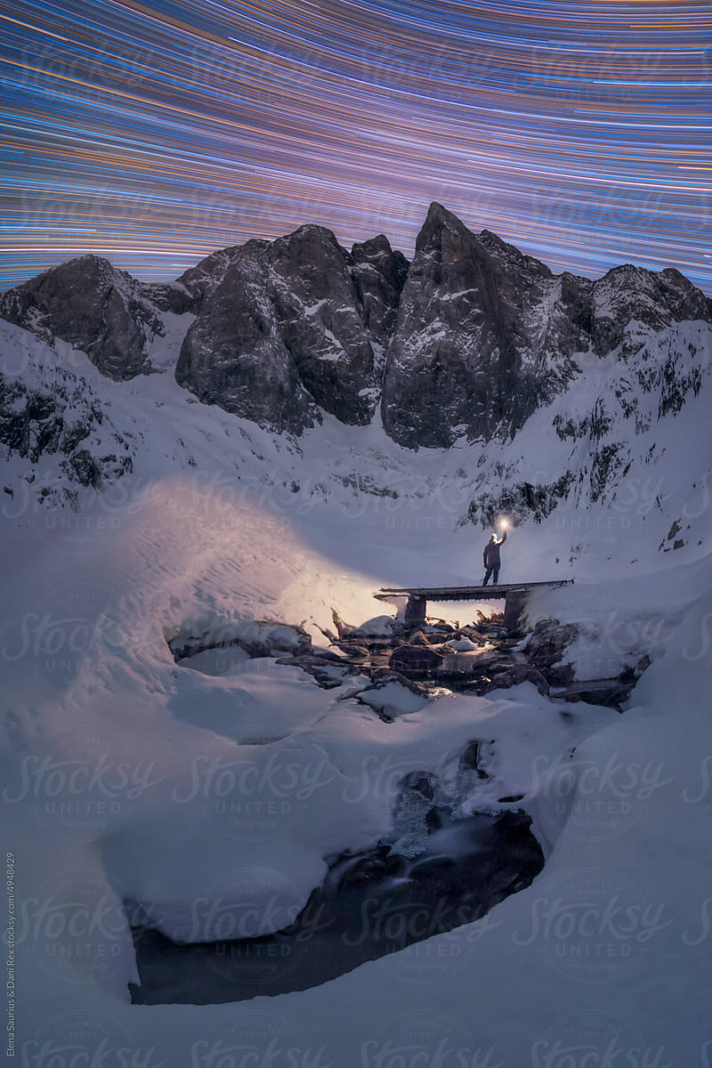 Star trail of snow Covered Mountain Peak with a person