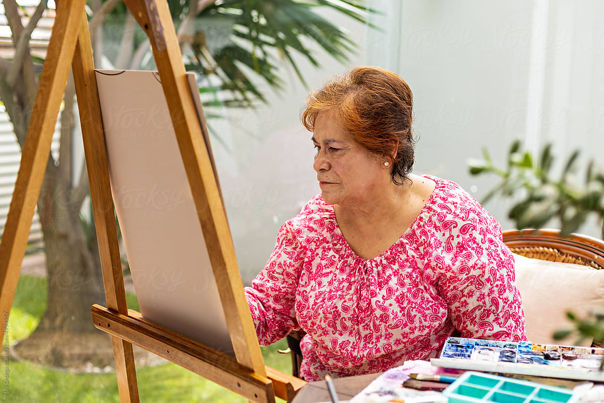 Elderly woman spending time in home studio creating work of art