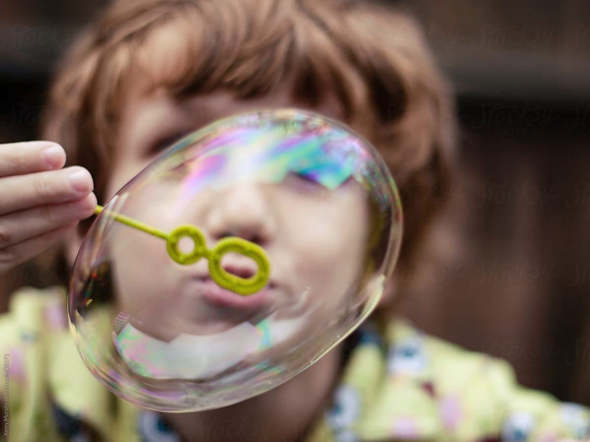 Young boy at blowing bubbles