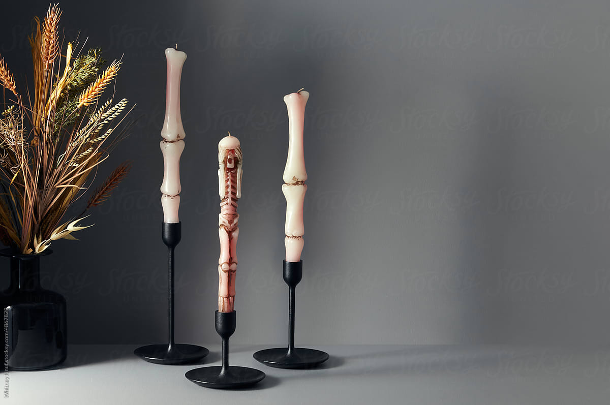 Spooky Skeleton Candles arranged in a still life on a gray background