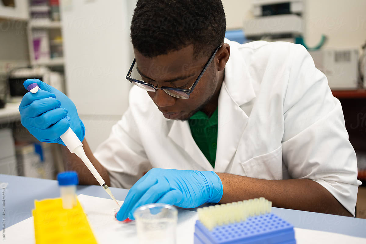 Black Scientist Focused Using The Pipette In The Lab.