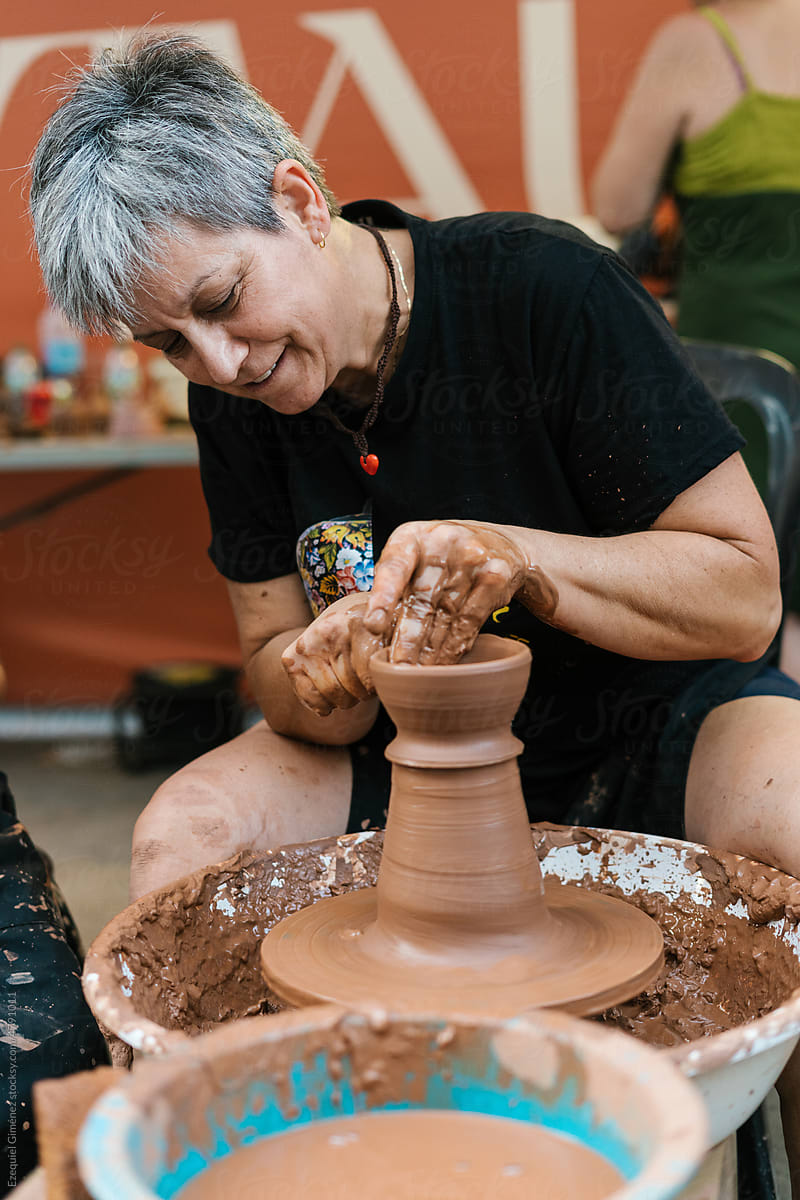 Woman making clay vase in workshop