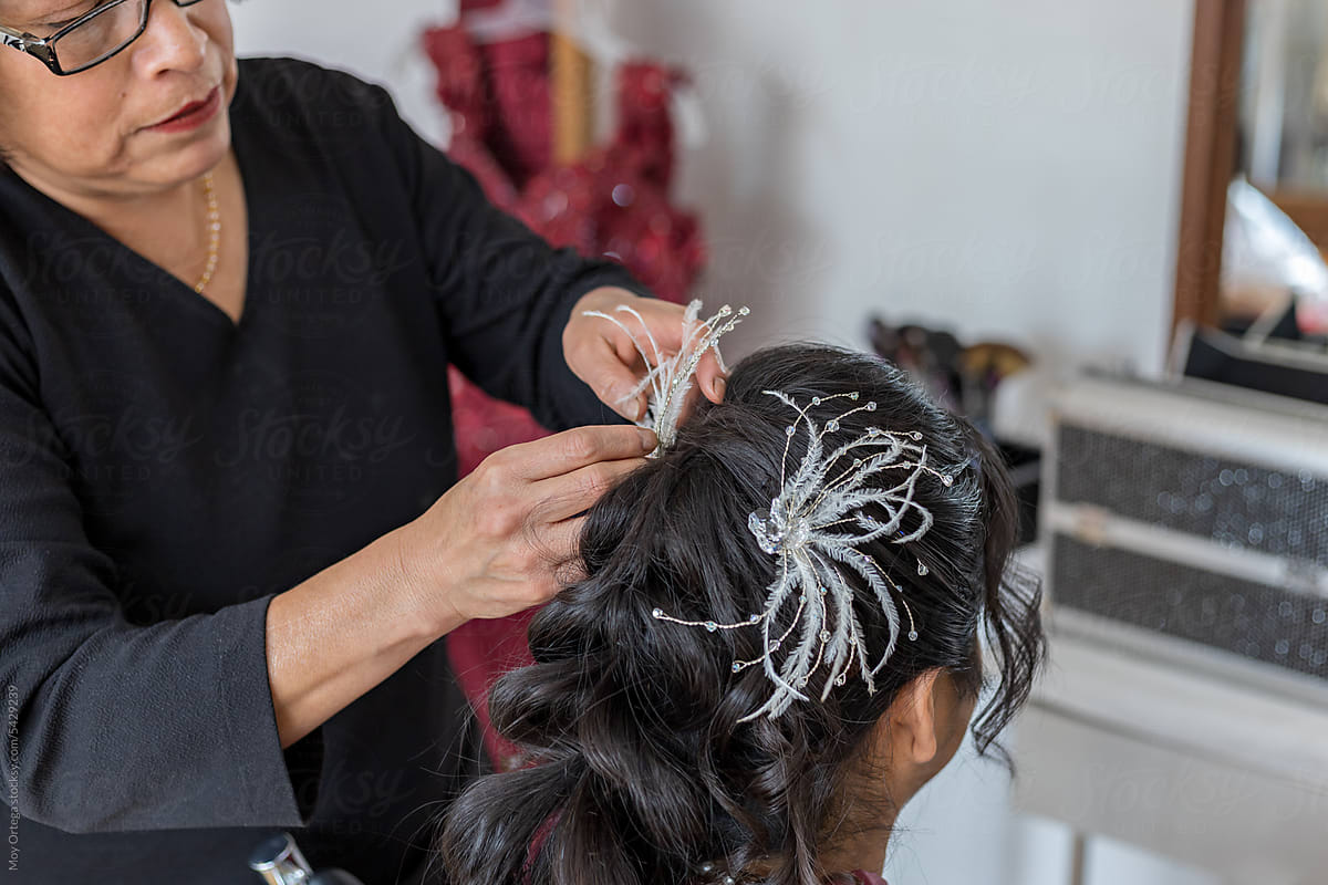 Stylist Attaches Feathered Hair Clips To Quinceanera Hairstyle