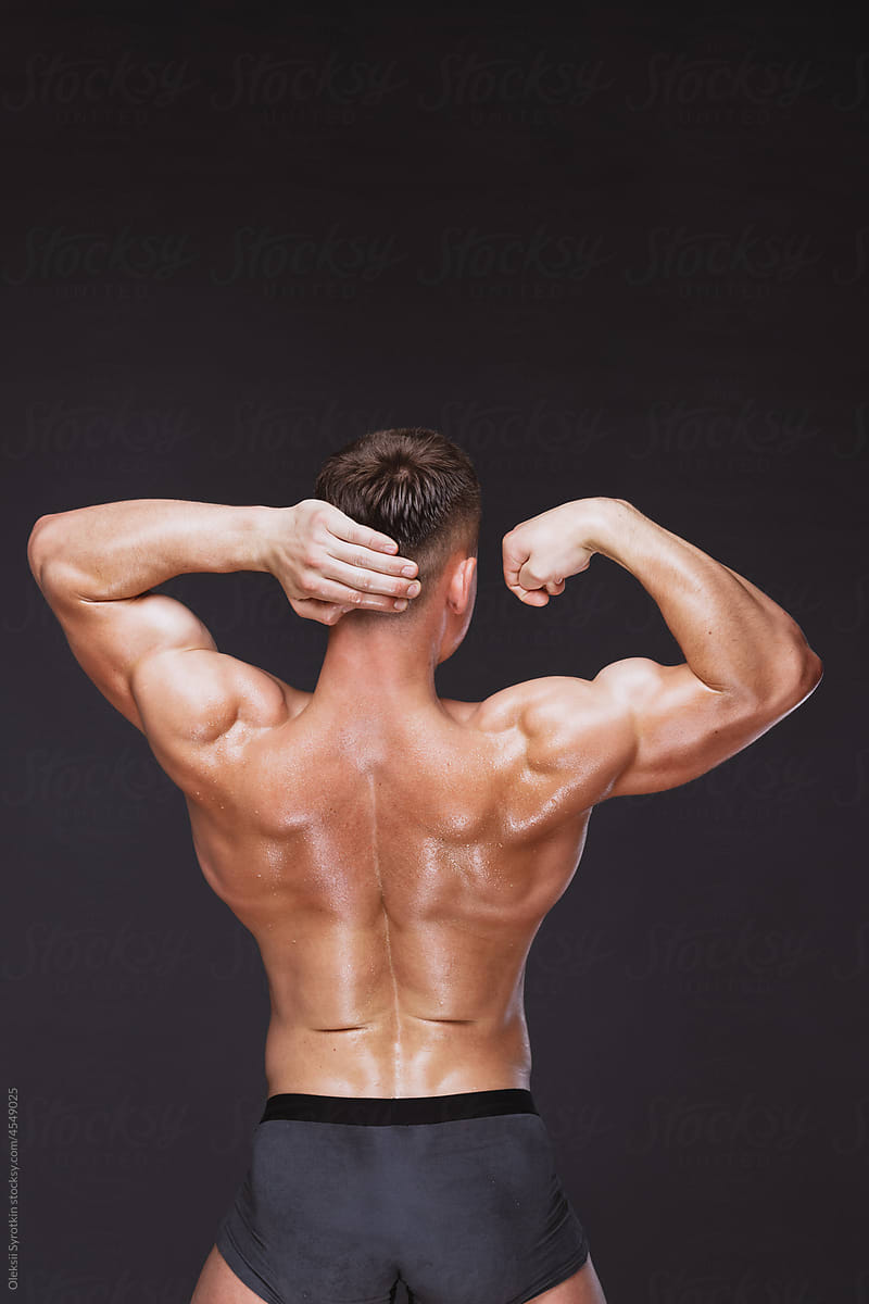 Strong male model showing back double muscles and shoulders