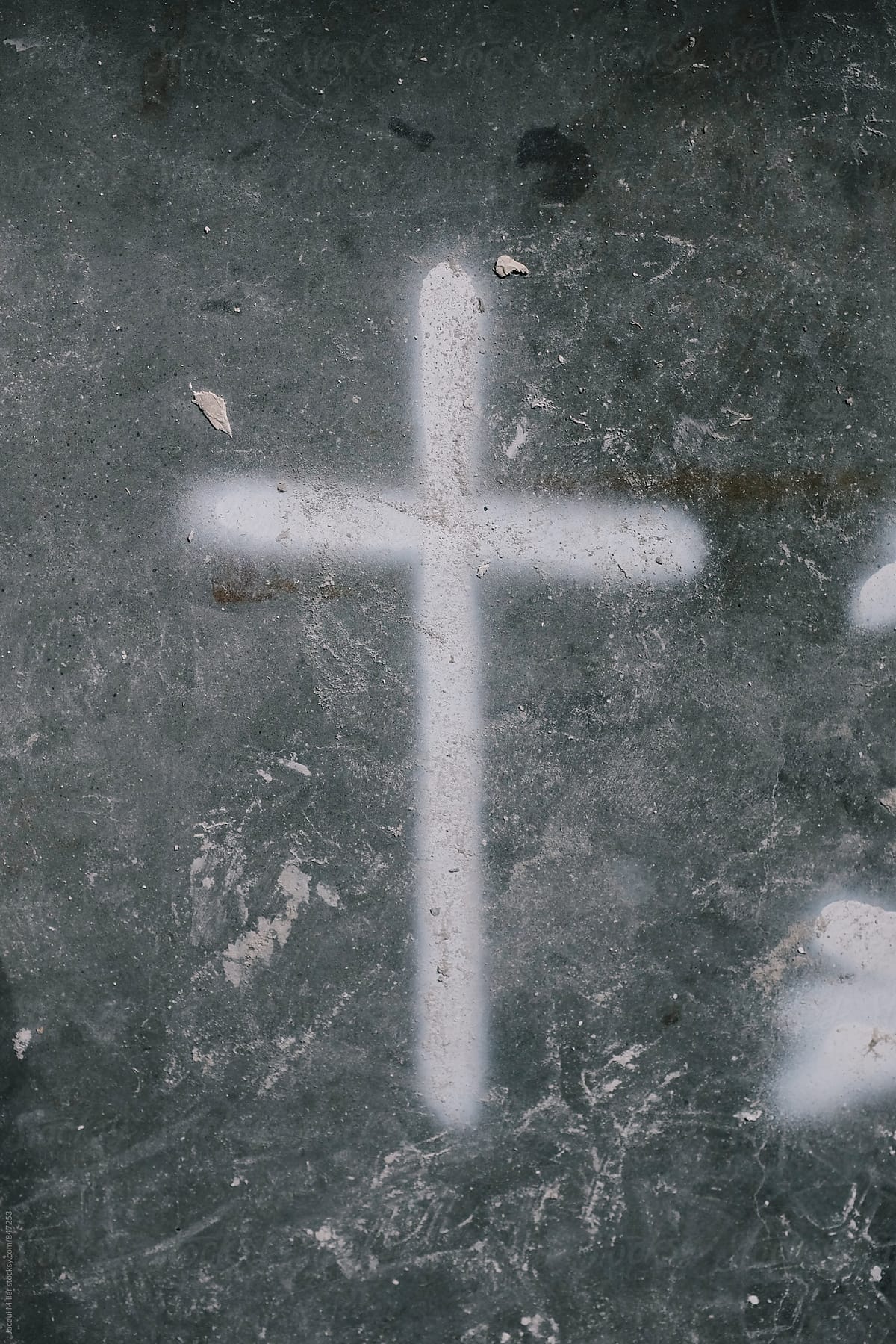 Cross painted on messy concrete floor