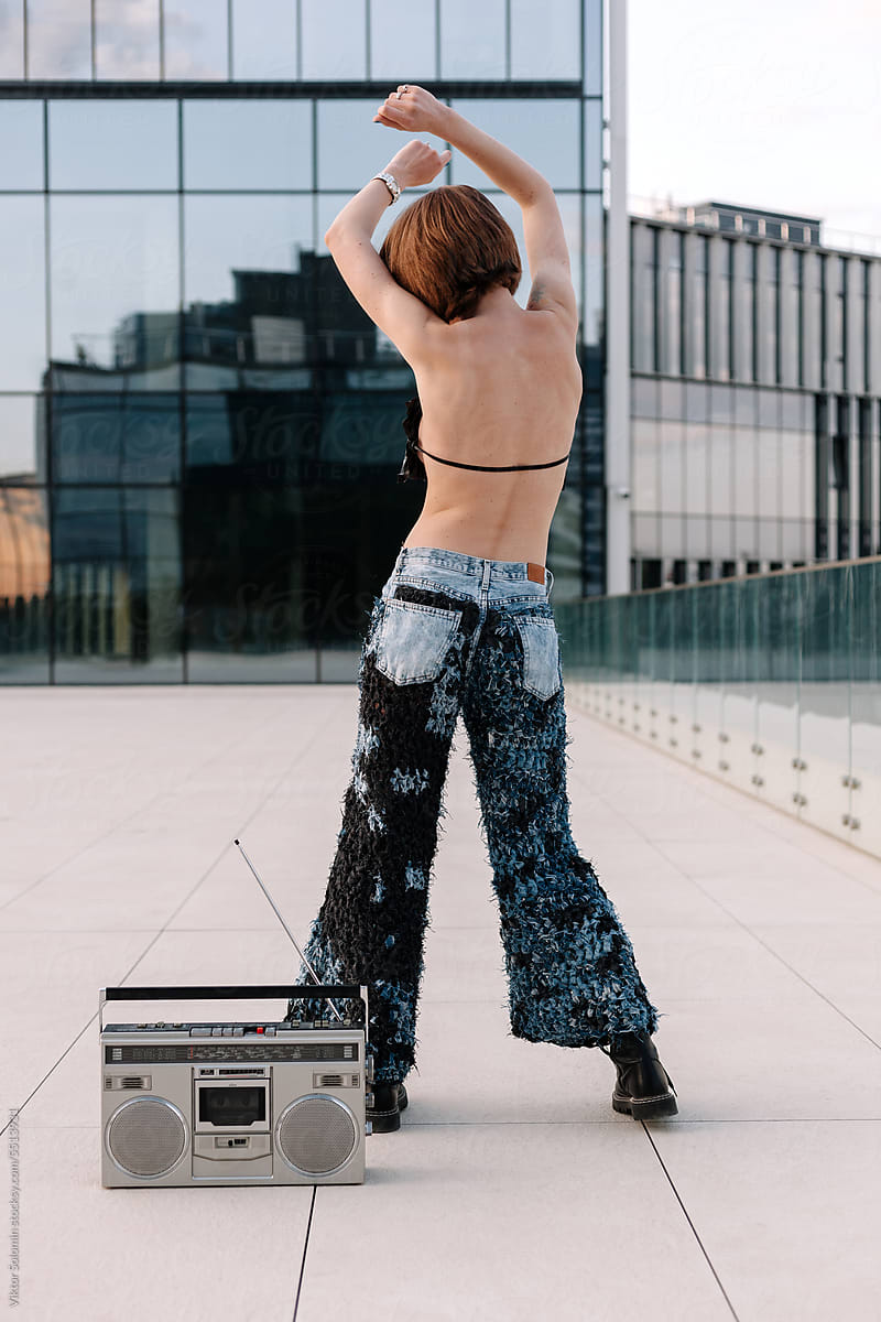 Slim faceless young woman dancing near tape recorder