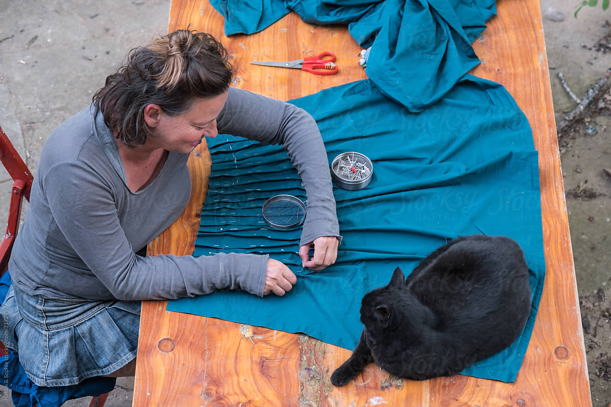 woman sewing with her cat watching