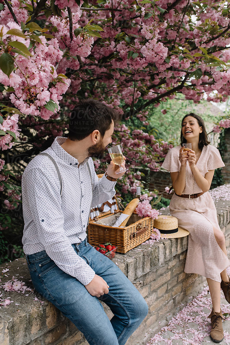 Young couple having picnic under cherry tree