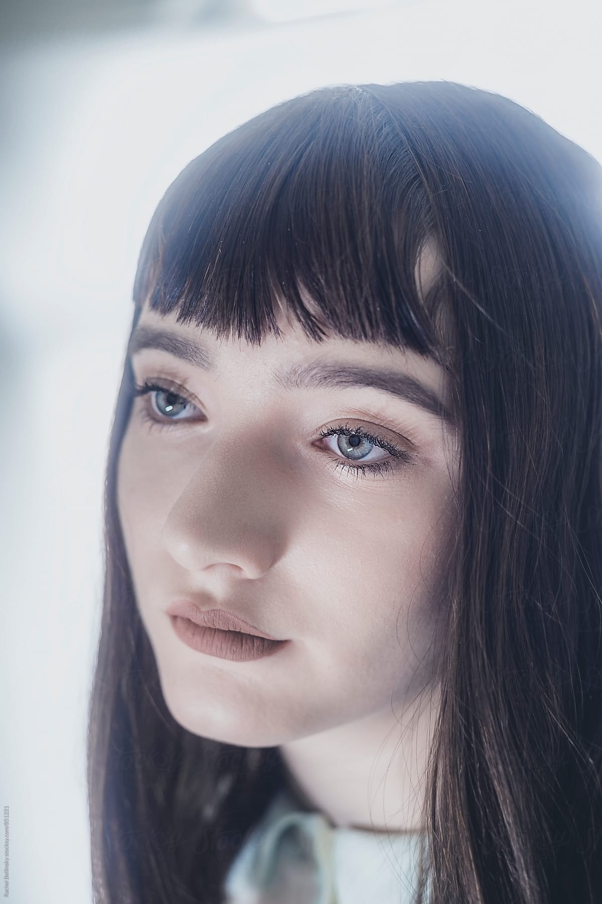 Portrait of a a beautiful young girl with dark hair and blunt bangs
