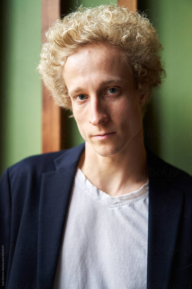 Blond male in jacket with curly hair