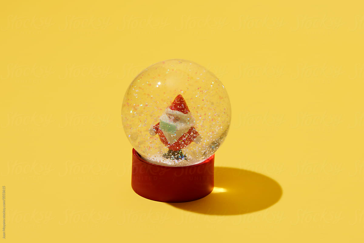santa claus wearing mask in a snow globe