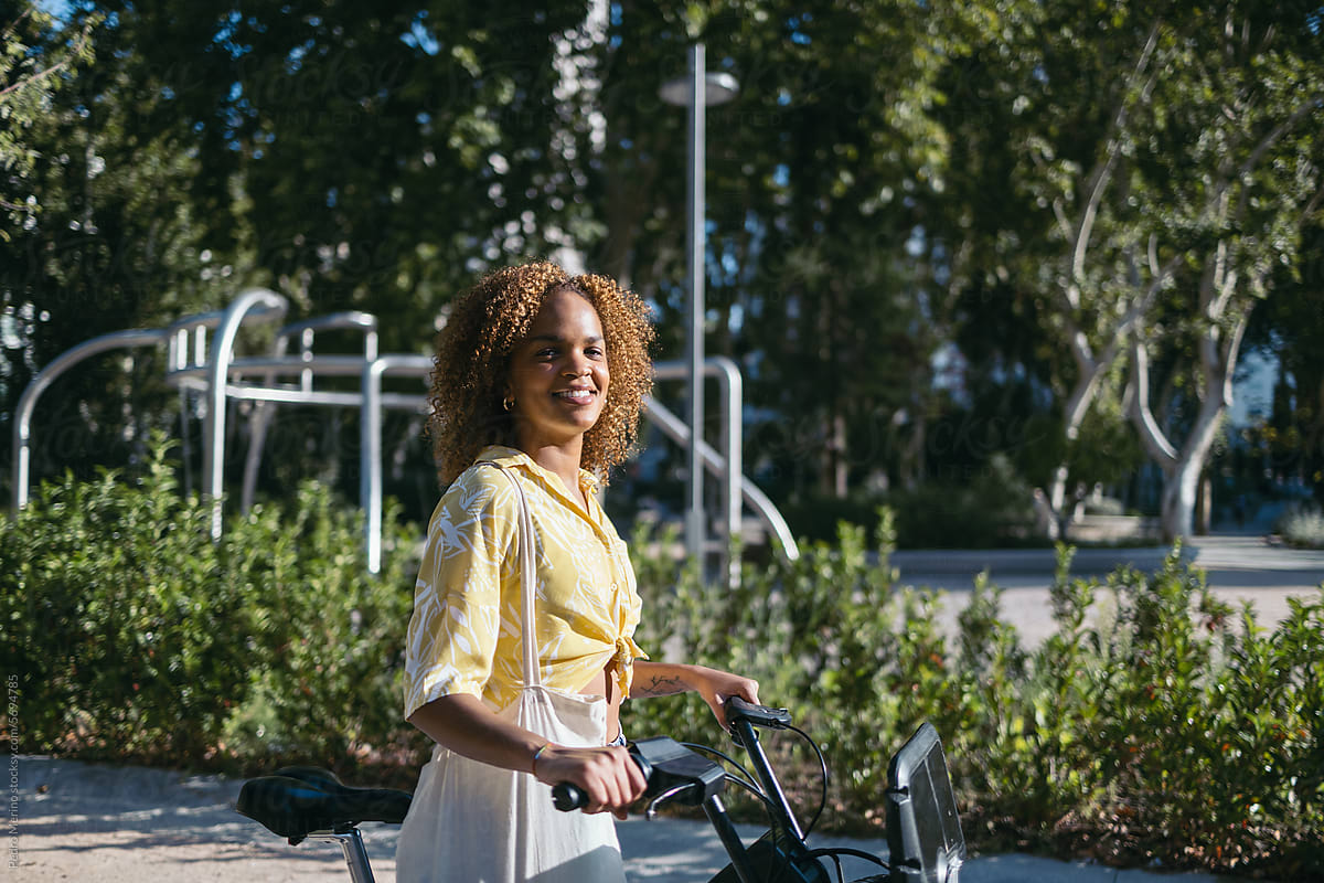 Portrait of a young woman with a rental electric bike in the city