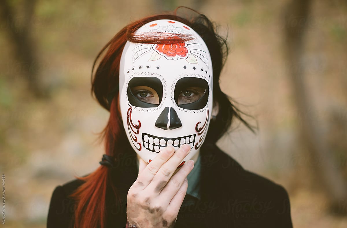 young woman wearing a Mexican sugar skull mask .
