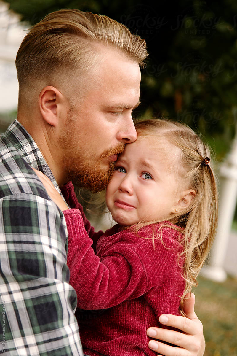 Man embracing crying girl