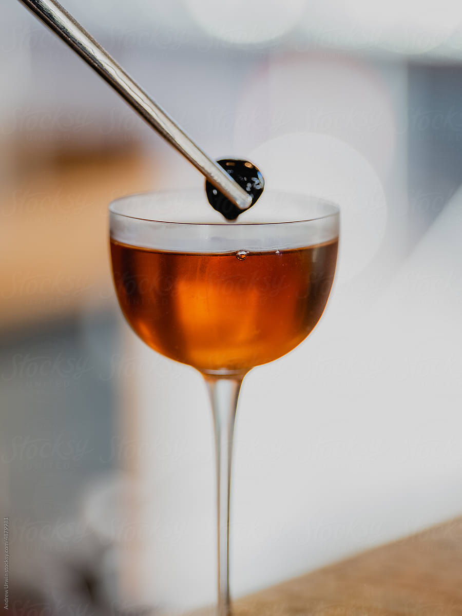 Brown cocktail in tall martini glass