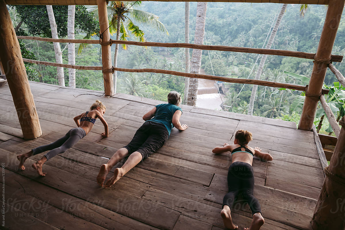 Energetic grandma teaching grandkids yoga in tropical vacation h