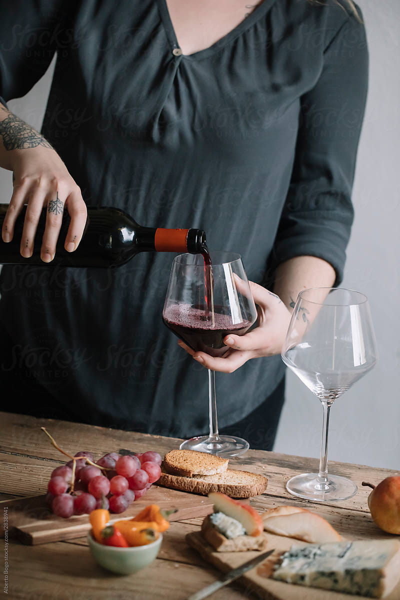 Woman Serving Red Wine And Snacks