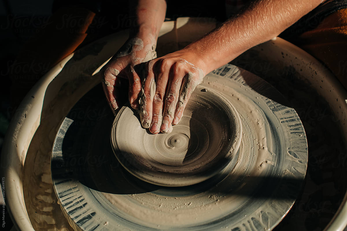 Hands crafting ceramic bowl on a pottery wheel