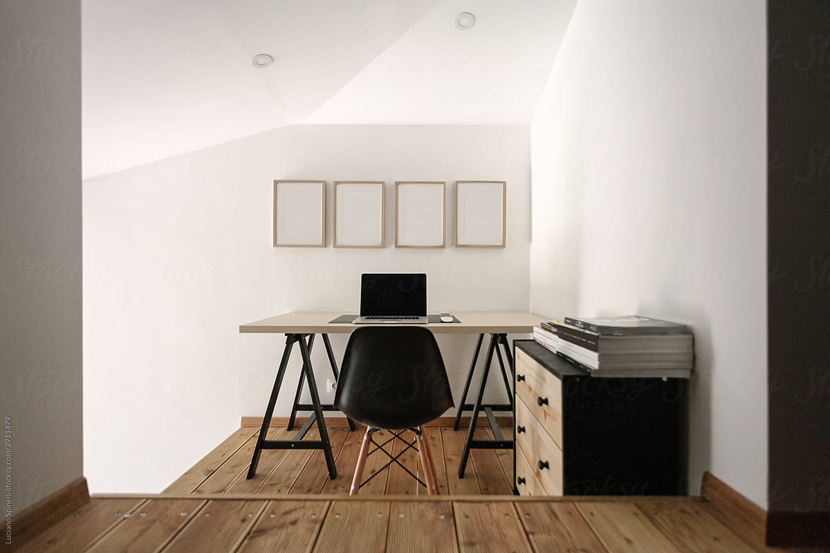 Minimalist home office with white frames on the wall
