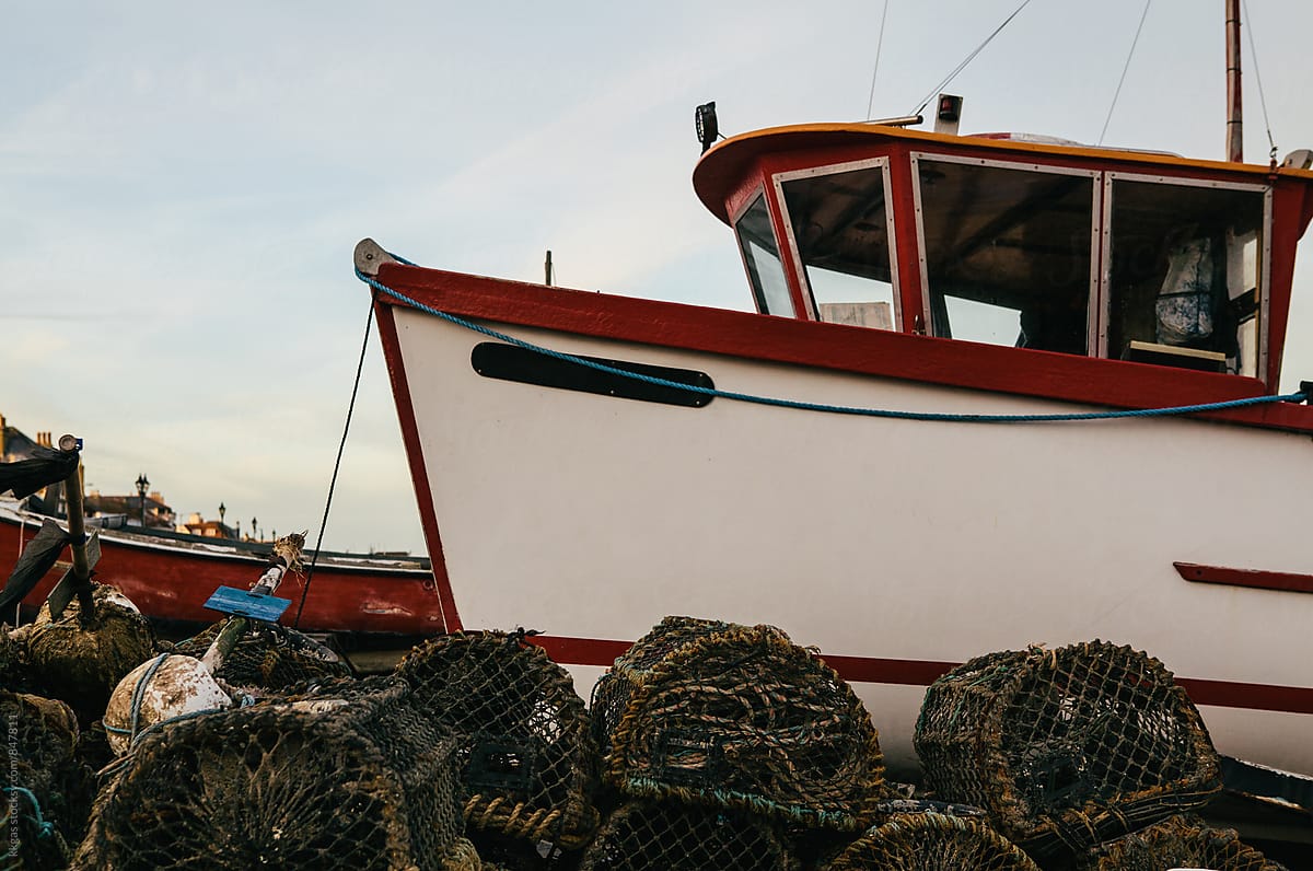 Fishing boat with lobster pots on an empty beach, Kent, UK.