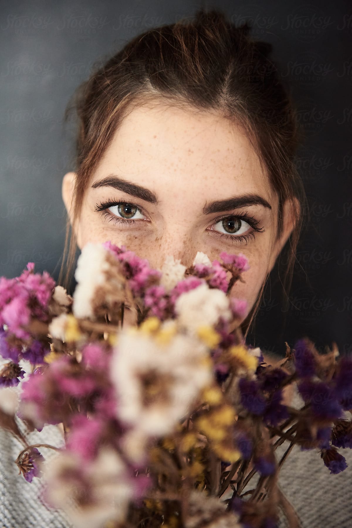 Attractive woman peeping out of bouquet