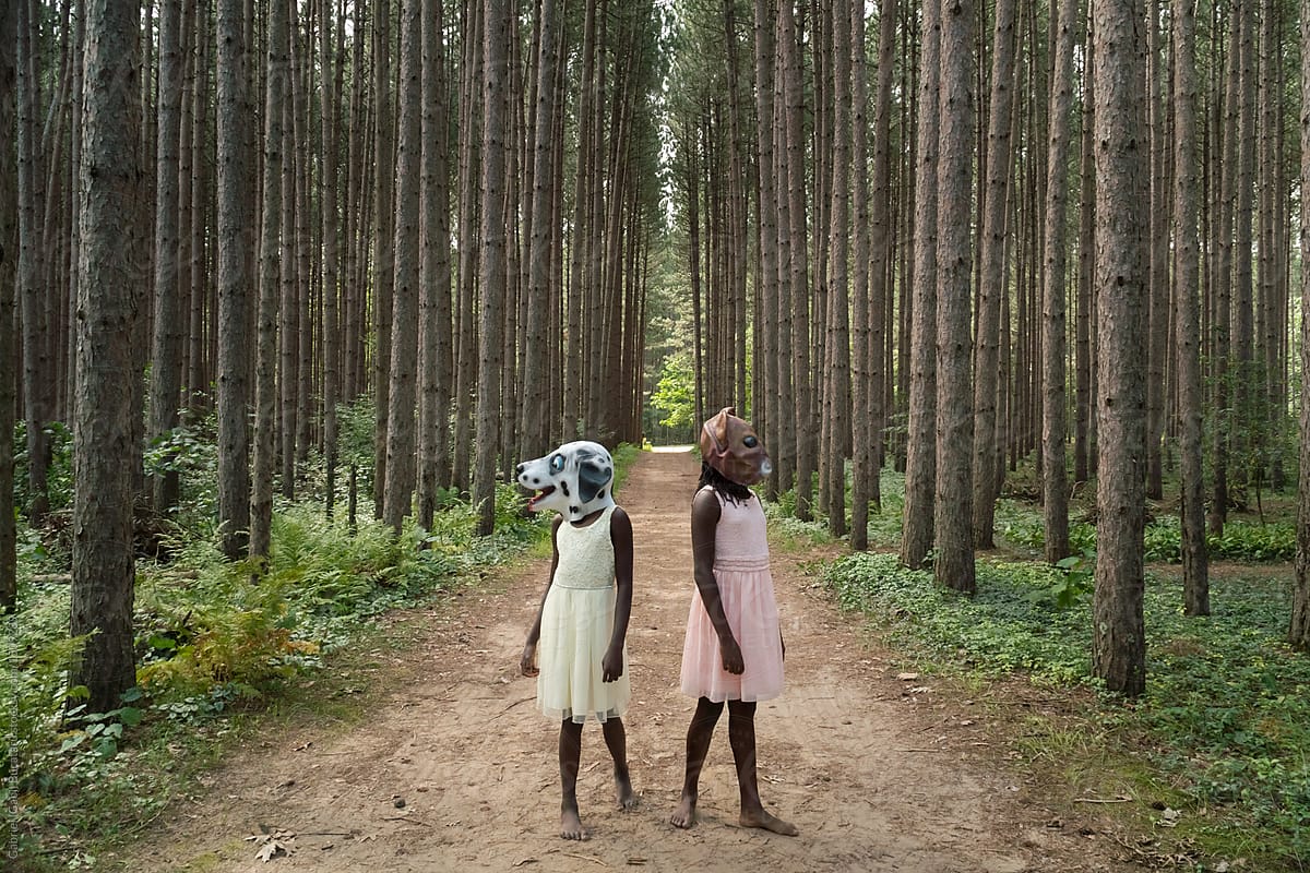 Two black girls in a forest wearing a dog and a squirrel mask