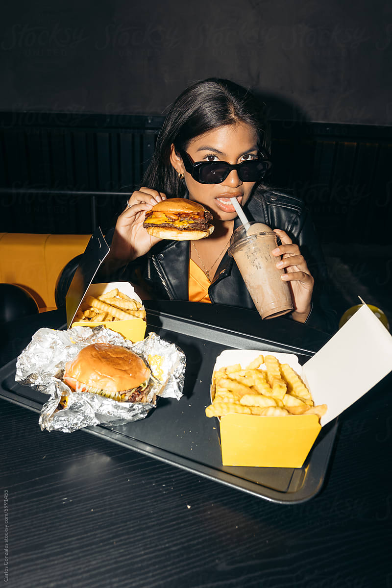 Woman drinking milkshake at a burger restaurant