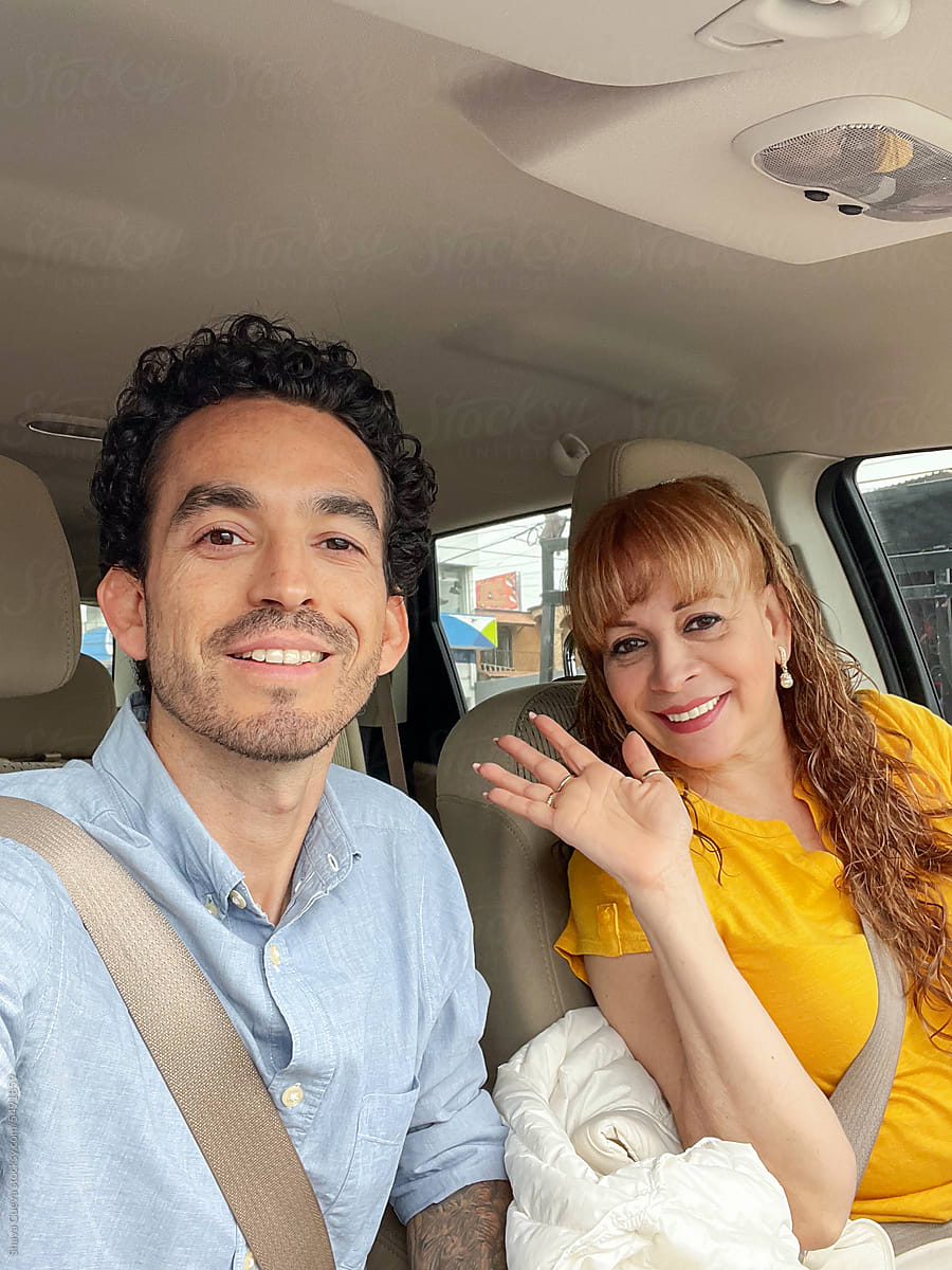 A mom and her son happily take a selfie in a car