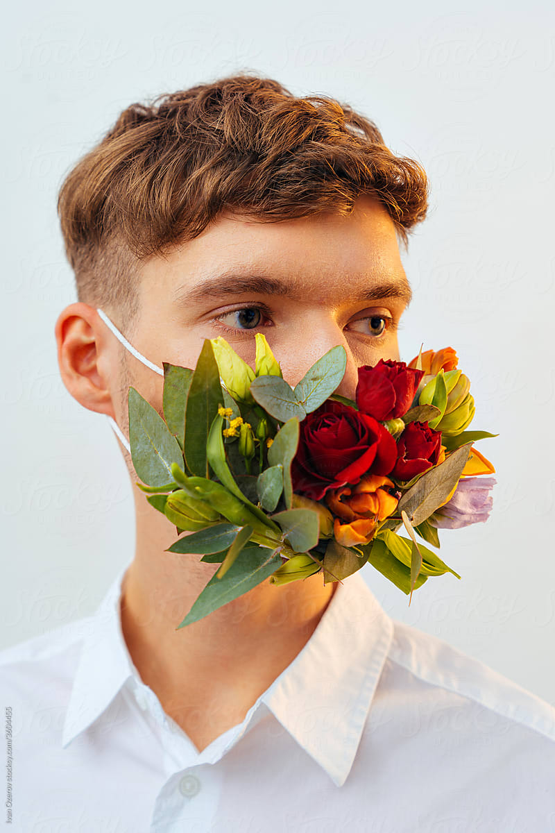 A man in a flower mask looks away