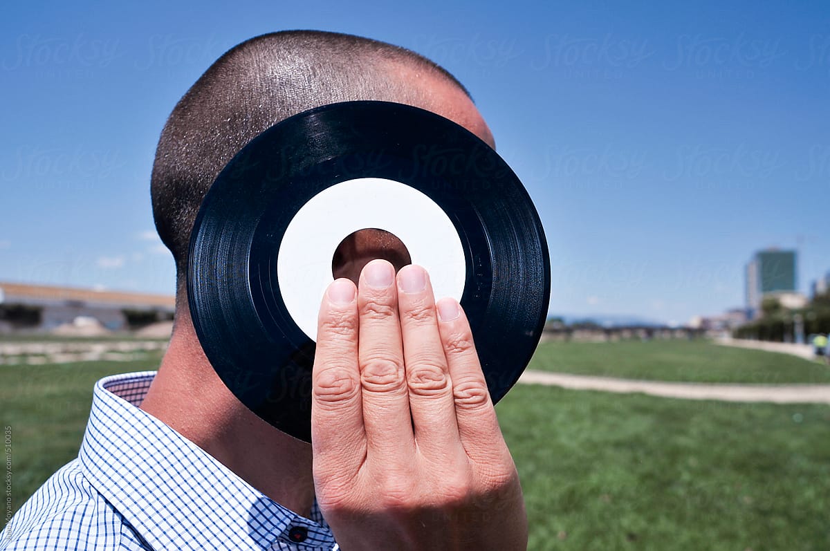 young man with a 45 rpm record at the park