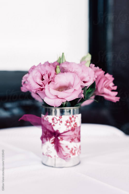 roses in a tin can with patterned paper and bow at a party