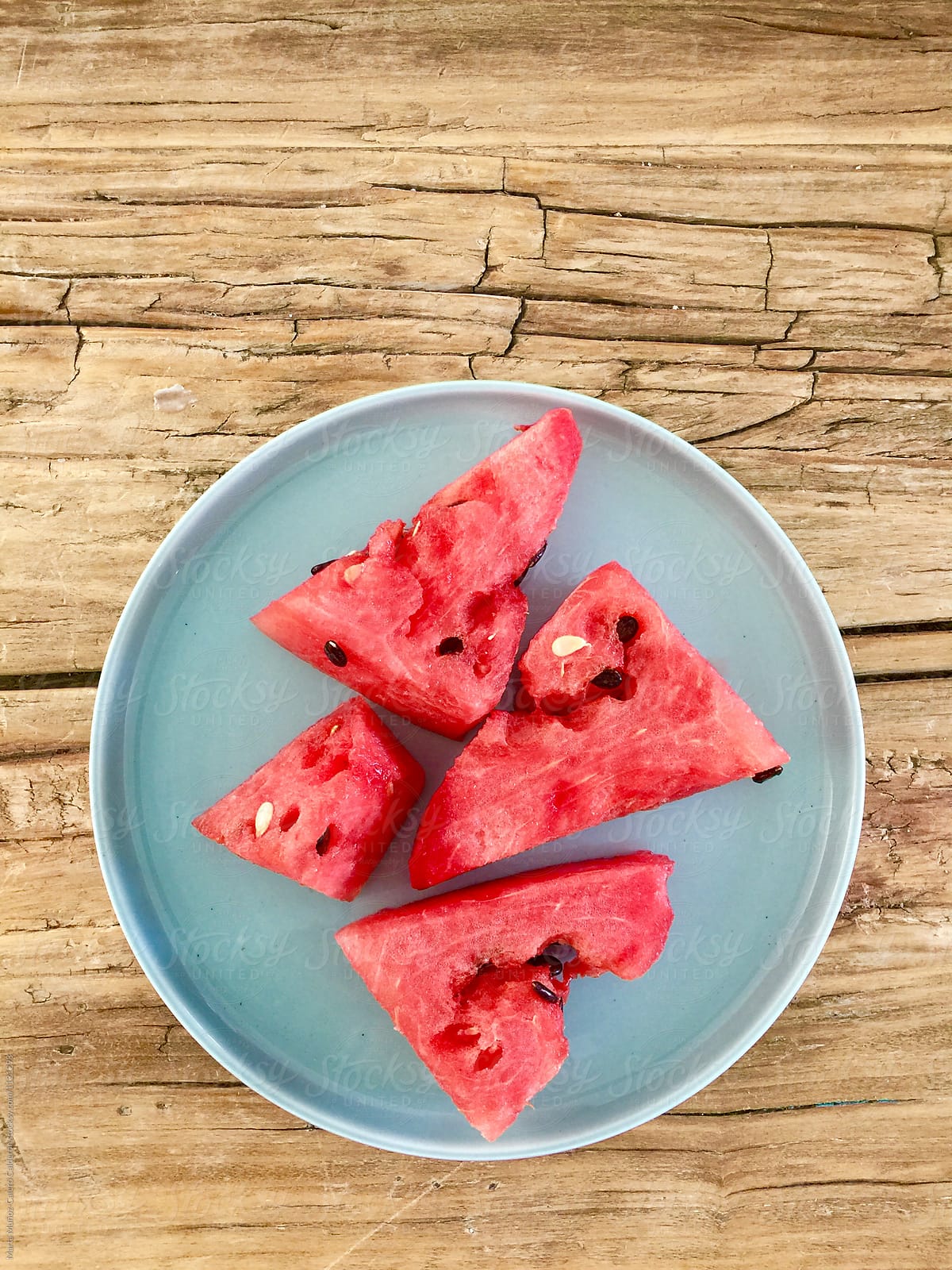 Water melon on a blue plate on a vintage wood table