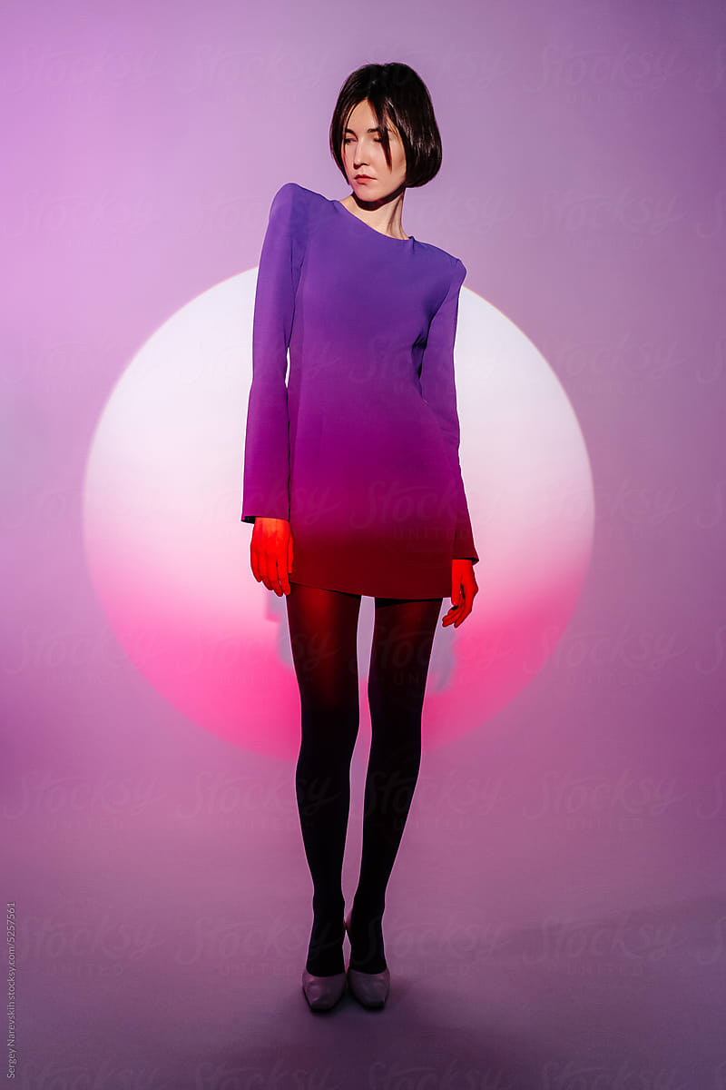 Woman in purple dress standing in studio