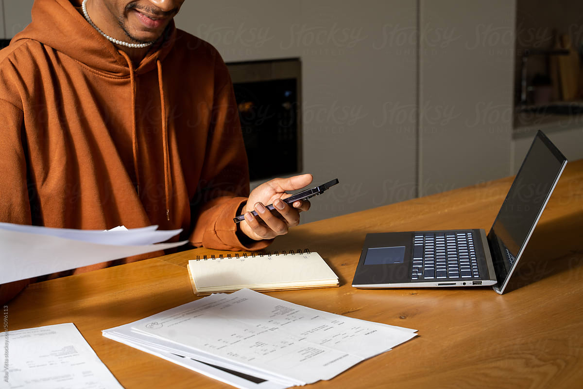 Man paying utility bills from home calculating expenses