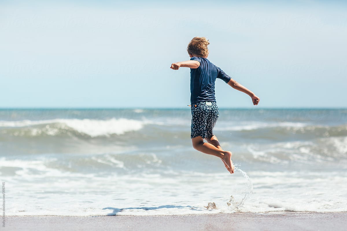 child jumping over ocean wave