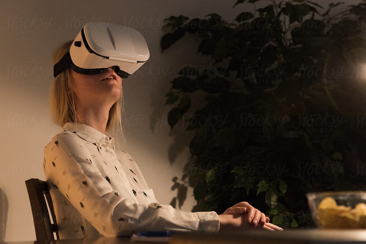 Young woman in VR glasses at table