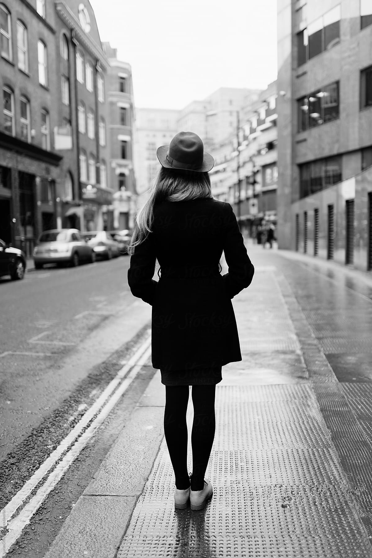 Young elegant woman in the street with hat and coat