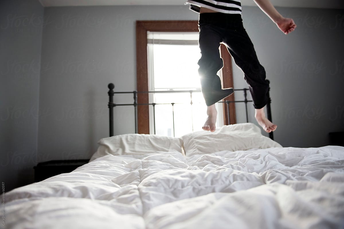 Happy Bouncing Child Jumps on the Bed at Home