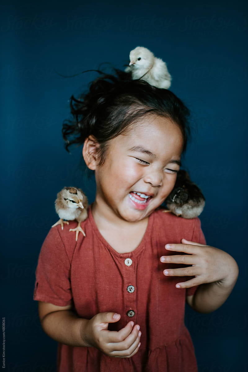 Girl laughing with chickens