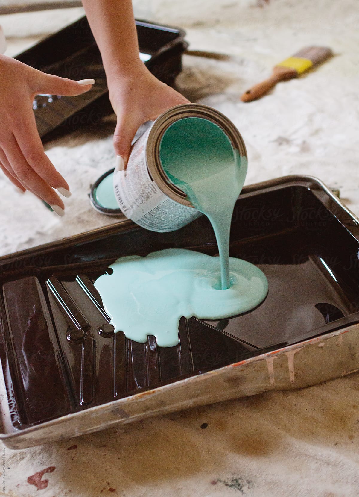 Young woman pours paint into a paint tray