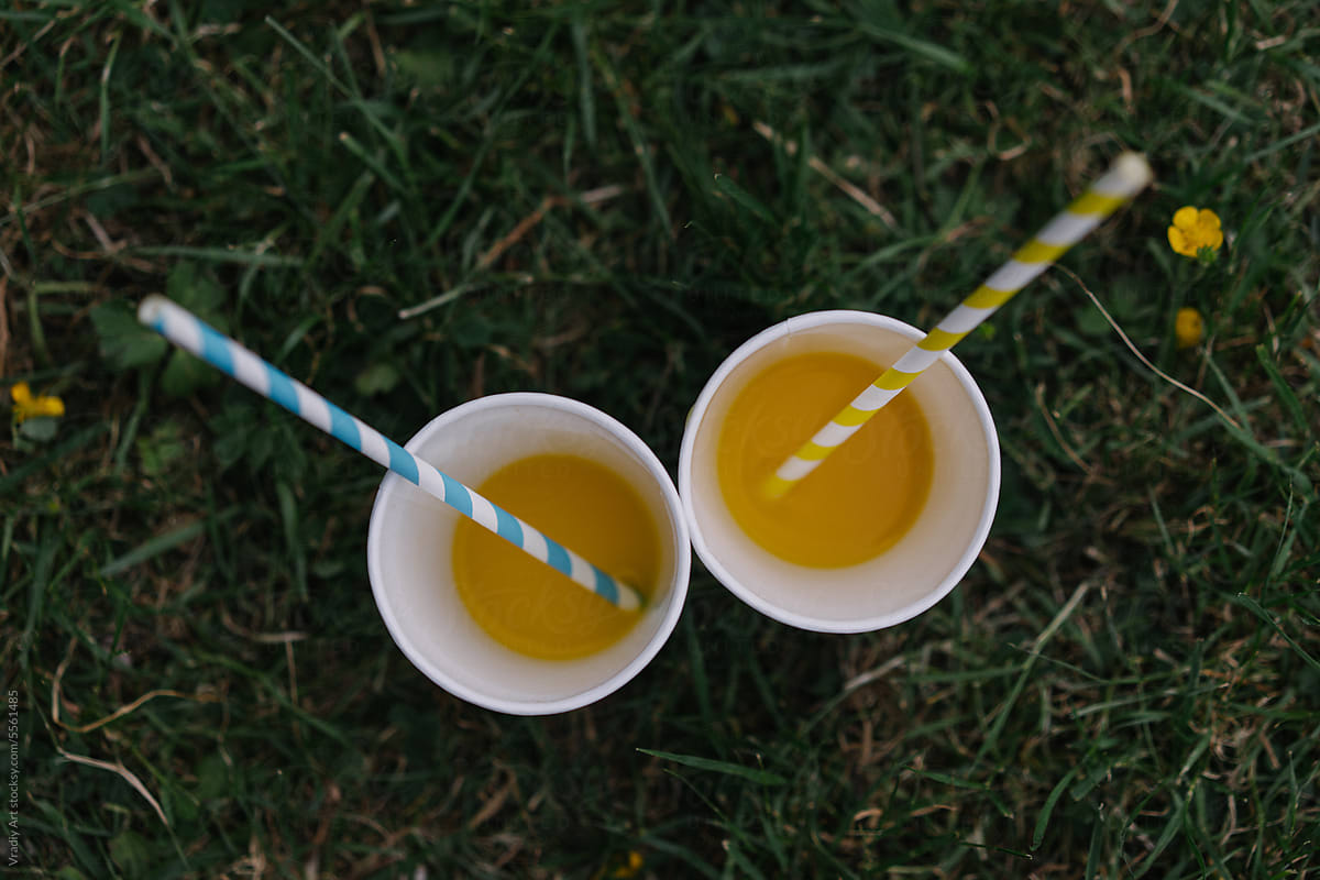 Orange juice in a blue cup with a straw
