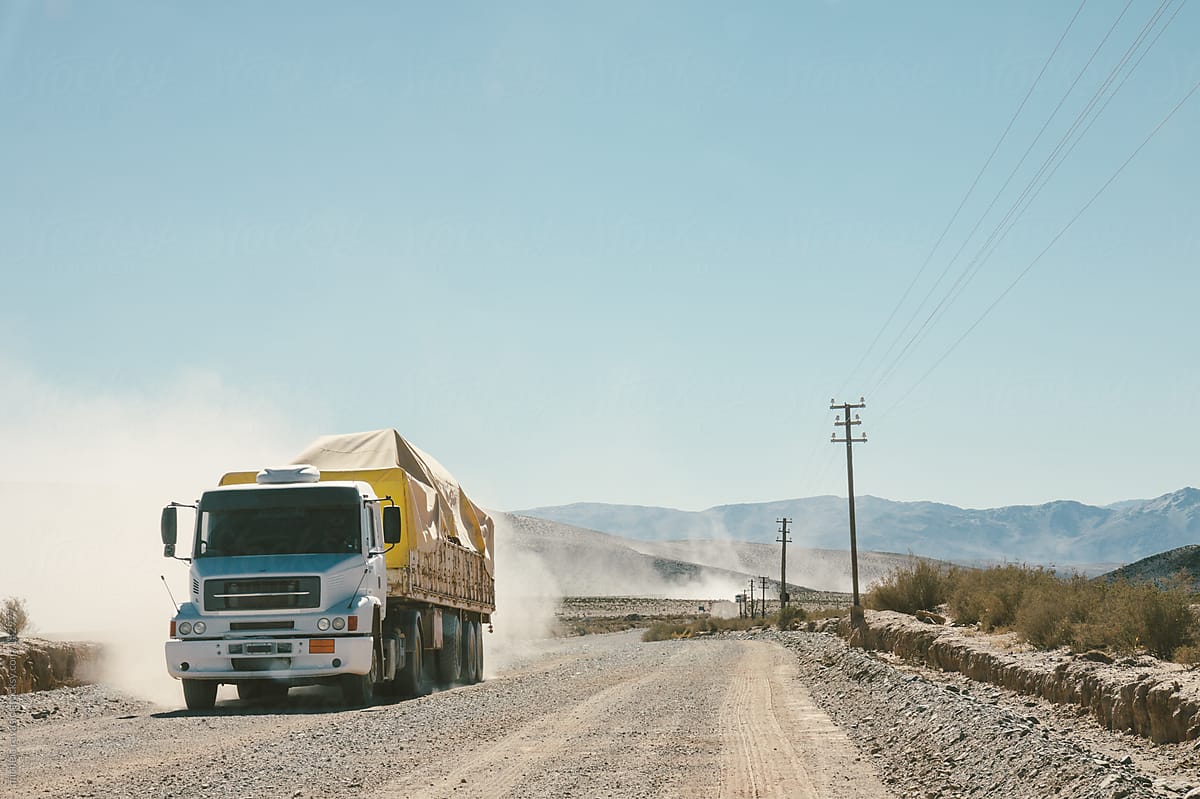 A truck along a dusty dirt road