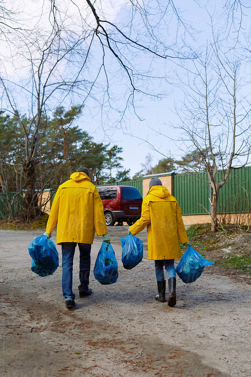 People carrying bags with garbage to car