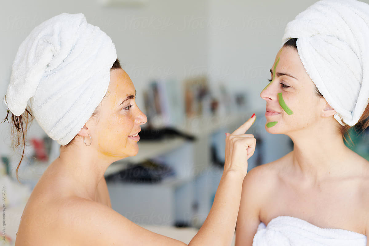 Woman applying mask on face of girlfriend
